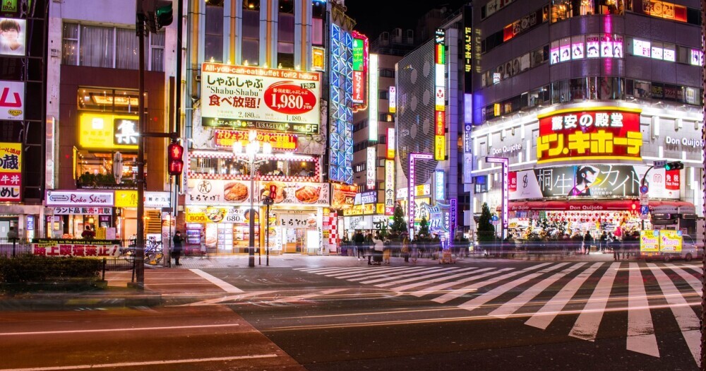 Photo of an intersection with lighted buildings