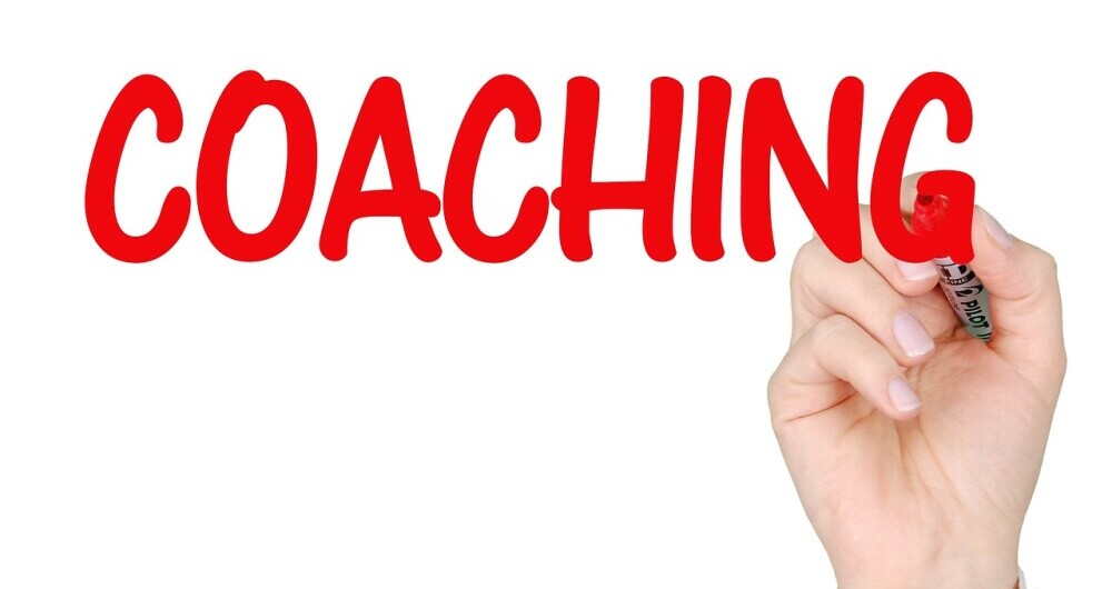 Hand holding sign saying  coach