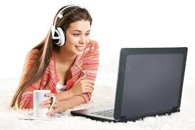 Woman with low vision wearing a headset and using a laptop to access an online webinar or training.
